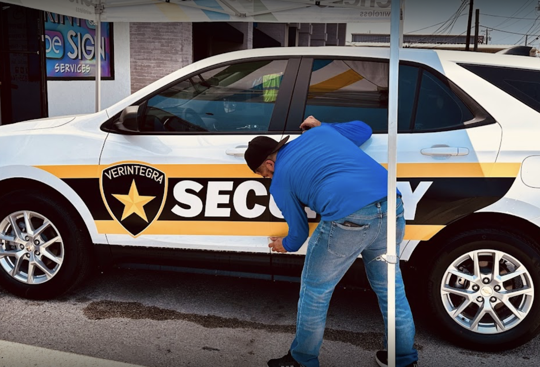 employee installing signage on car